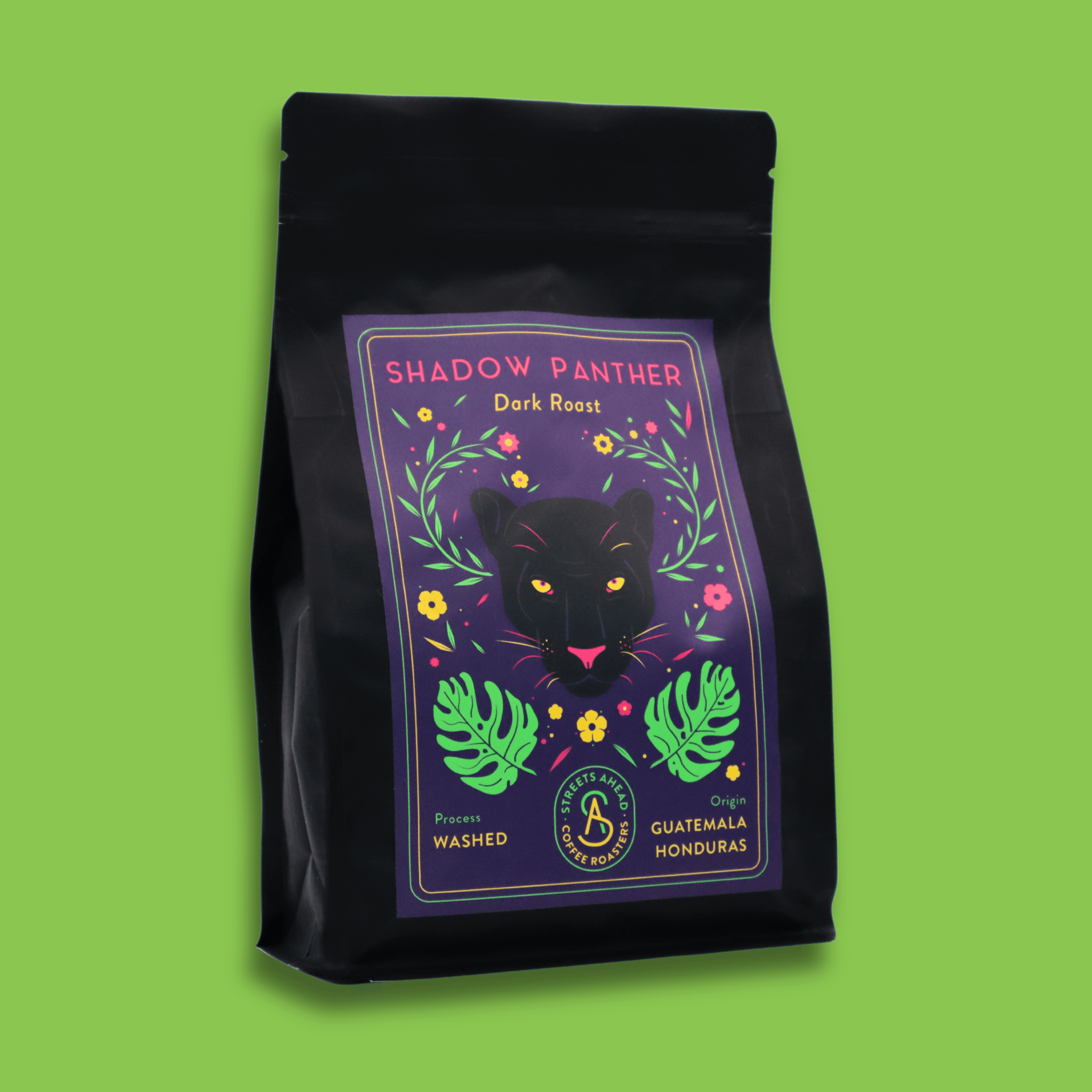 A 340g bag of dark roast, whole bean, Shadow Panther specialty coffee sitting in front of a green background.