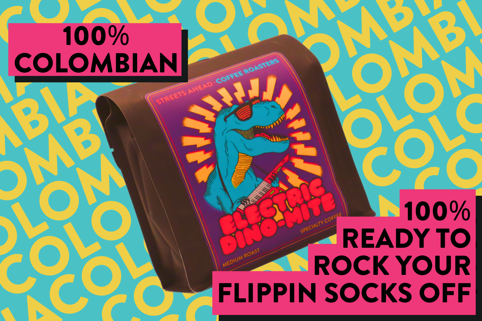 A coffee bag labeled Electric Dino-Mite by Streets Ahead Coffee Roasters, featuring a colorful dinosaur graphic on a purple label, set against a bright blue background with yellow 'COLOMBIA' text and pink promotional badges.