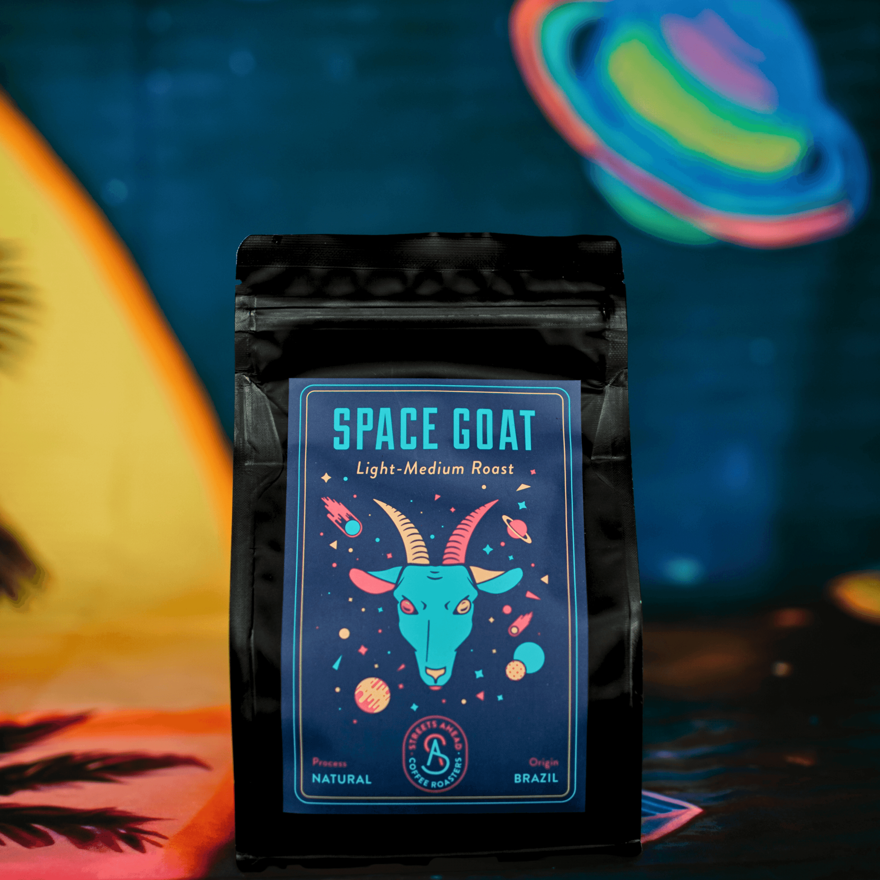 Light roast, whole bean, specialty coffee bag featuring a drawing of a goat head in space, standing in front of a space themed background.